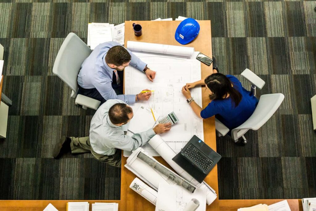 Construction Management Team at Drafting Table from Above